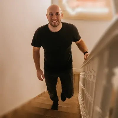Malte Witt auf einer Treppe, lächelnd